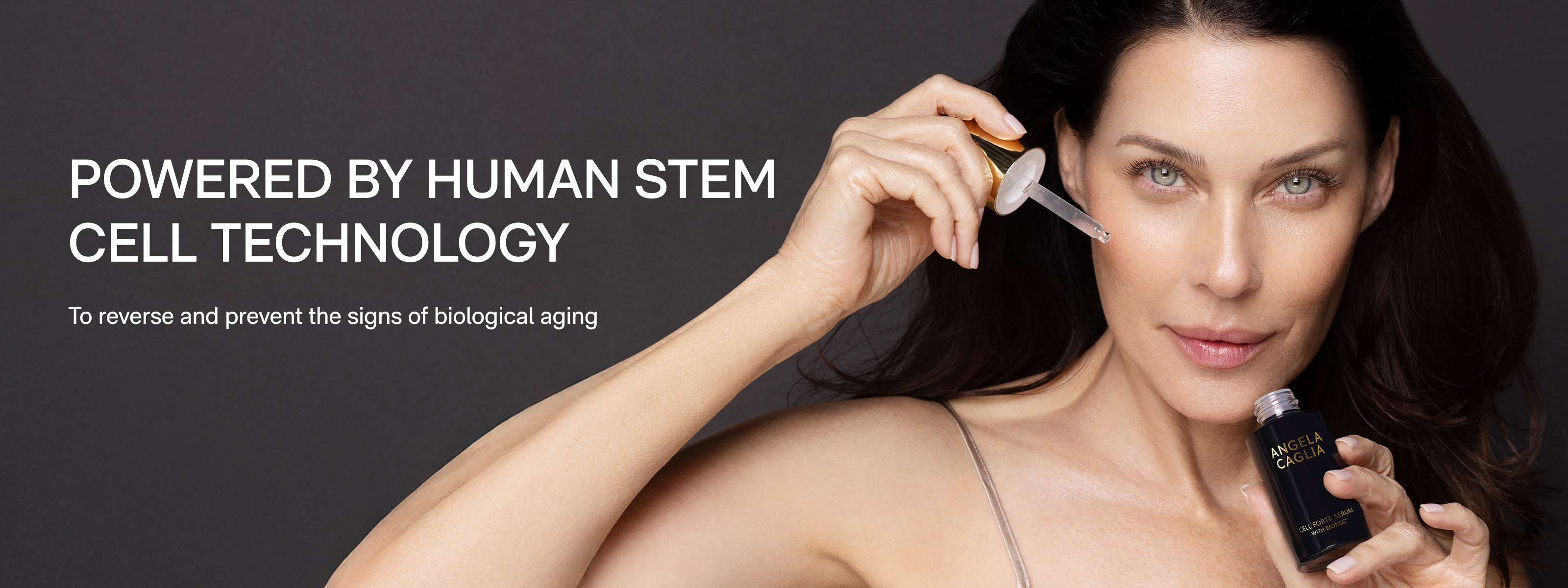 Brunette model holding dropper to side of face.